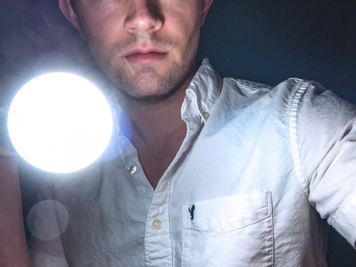 Man holding a bright flashlight